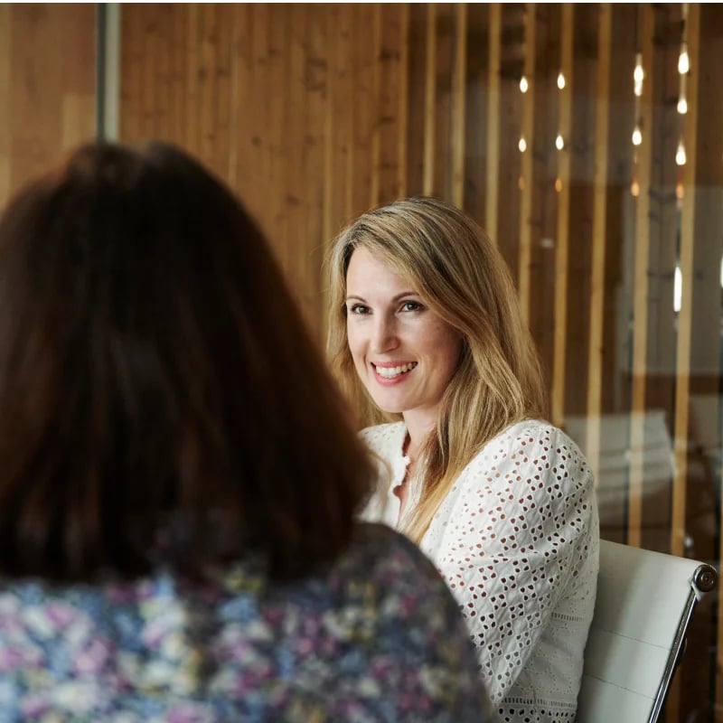 payroll workflow female employee smiling at colleague