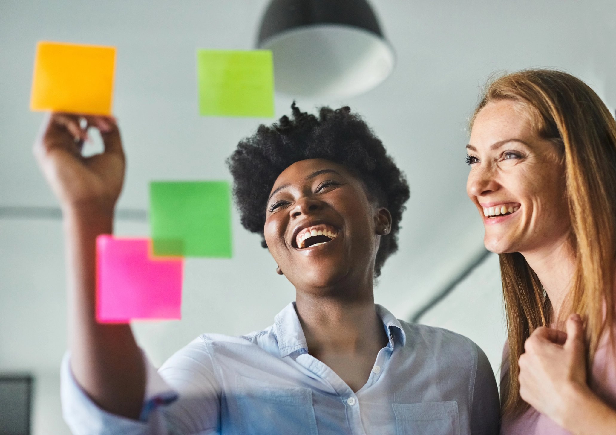 Two women smiling with post it notes