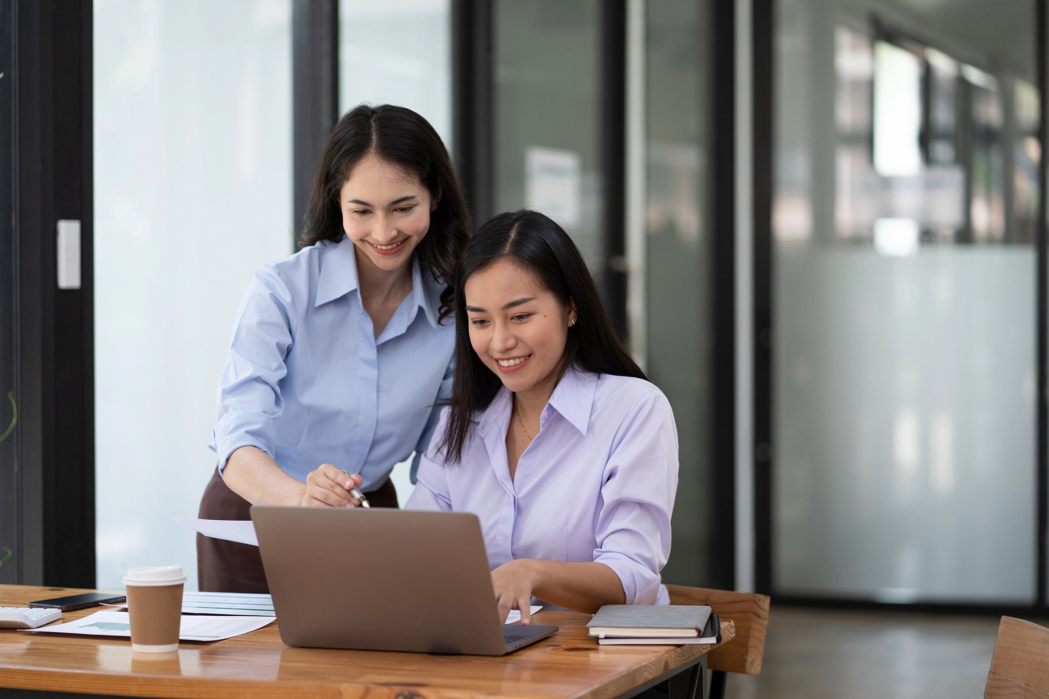 Twee vrouwen kijkend naar Nmbrs salarissoftware op hun laptop